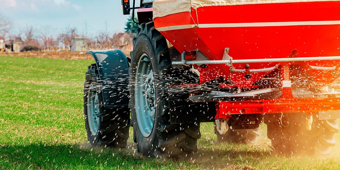Implemento agrícola realizando adubação nitrogenada no solo.